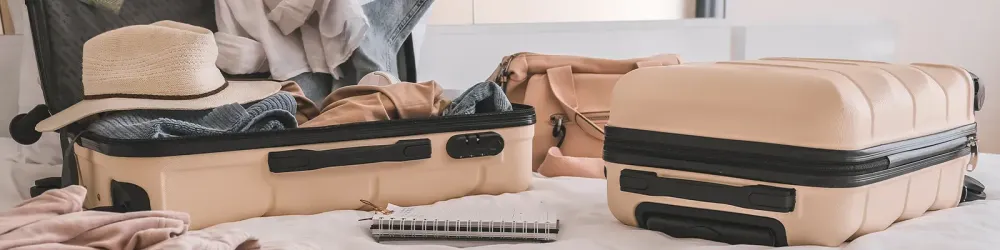 Suitcases open and unpacked on a bed